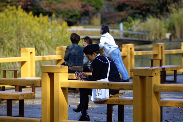 A girl sitting in front of the fountain area.